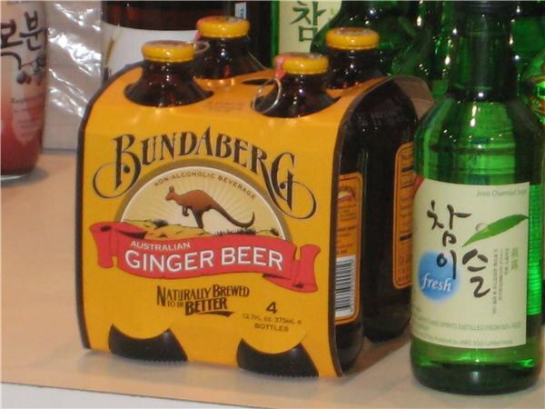 A yellow four-pack of Bundaberg Australian Ginger Beer bottles with a kangaroo logo, beside a green bottle with Korean lettering.