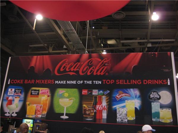 Large Coca-Cola banner reading Coke Bar Mixers make nine of the ten top selling drinks, with images of mixed drinks and Minute Maid, Seagram's and Full Throttle branding.