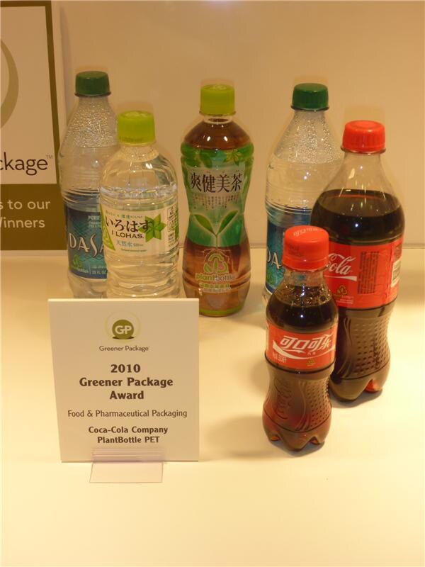 Bottles of DASANI, I LOHAS, a green tea and Coca-Cola stand behind a 2010 Greener Package Award sign for Coca-Cola Company PlantBottle PET.