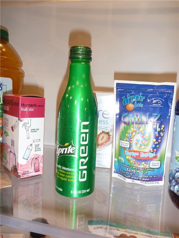 Shelf display with a green aluminum Sprite Green bottle between a Hansen's Natural fruit stix box and a Dippin' Dots Chillz Mango Rainbo rainbow ice pouch.