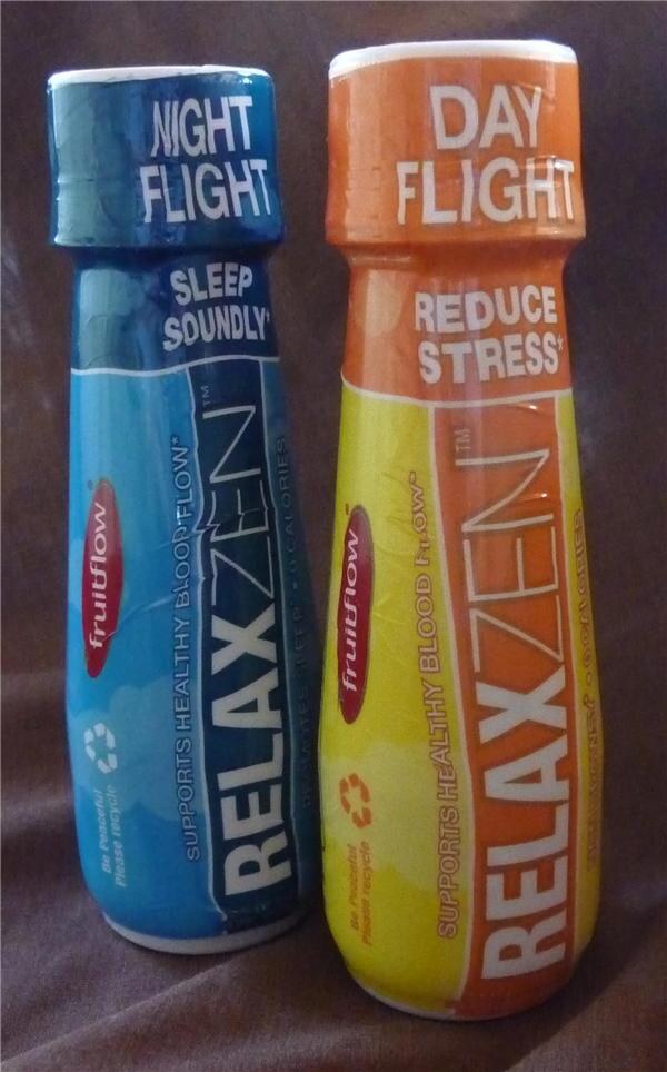 Two Relaxzen bottles stand side by side against a brown cloth. The blue Night Flight bottle says Sleep Soundly. The orange and yellow Day Flight bottle says Reduce Stress. Both carry a Fruitflow logo.