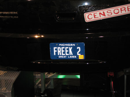The rear of a black vehicle shows a blue Michigan license plate reading FREEK 2 and a red-and-white Censored sticker in the corner, with Freek lettering on the left.