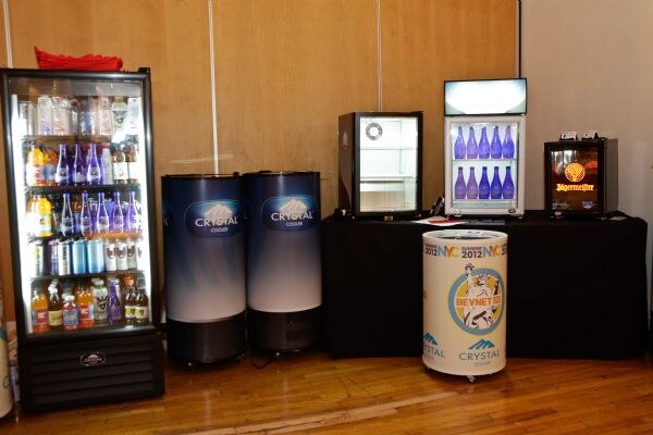 Crystal Cooler display of refrigerators: a glass-door cooler with bottled drinks, two Crystal Cooler drum coolers, small countertop coolers including a Jägermeister one, and a BevNET-branded round cooler.