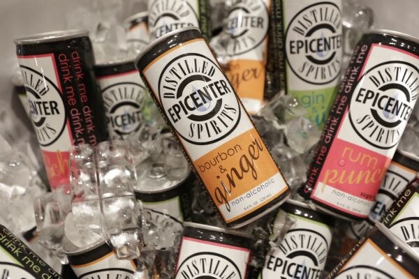 Close view of Distilled Epicenter Spirits cans in ice, with bourbon & ginger and rum punch flavors visible among other flavors.