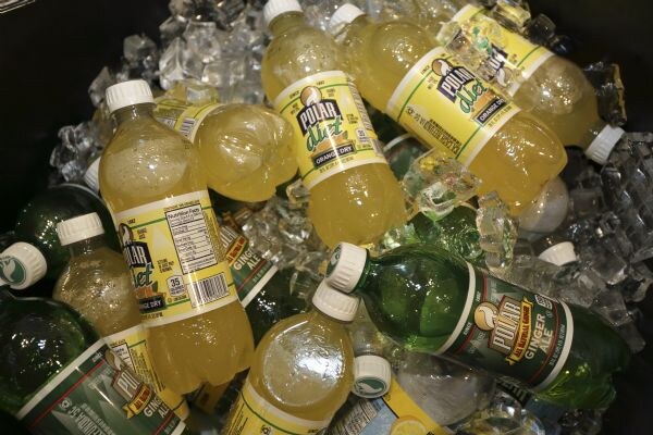 Plastic bottles of Polar Diet Orange Dry soda and Polar Ginger Ale nestled in a bed of crushed ice.