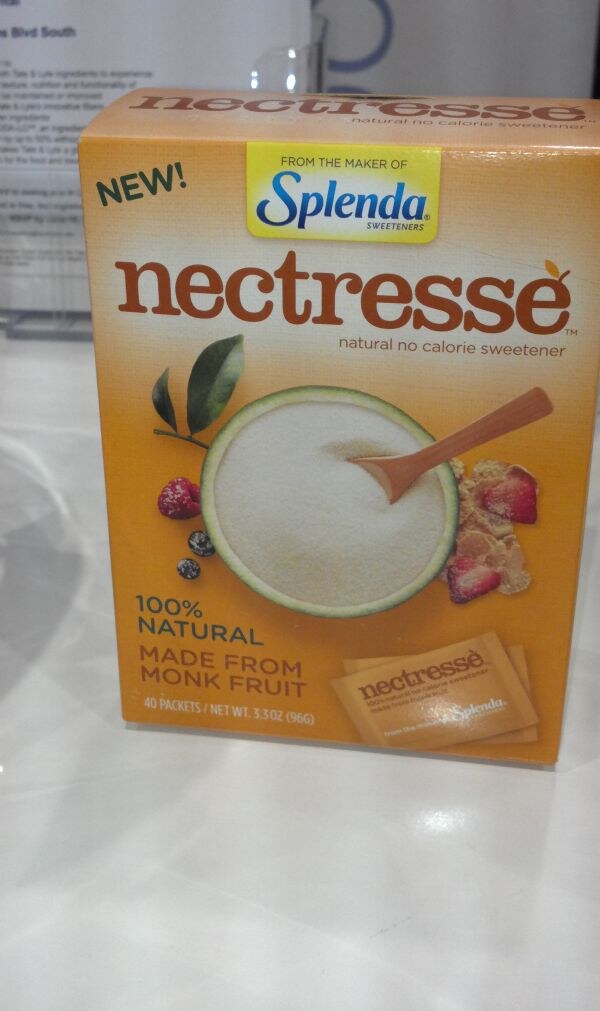 An orange box of Nectresse natural no calorie sweetener, labeled new and from the maker of Splenda, made from monk fruit, 40 packets, on a white surface.