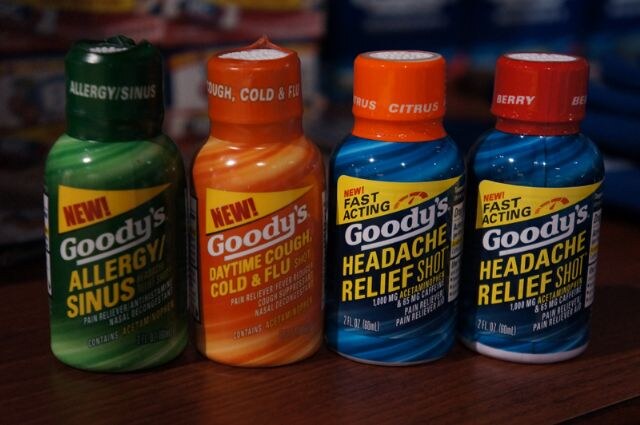 Four Goody's shot bottles in a row: Allergy/Sinus in green, Daytime Cough Cold & Flu in orange, and two Headache Relief Shot bottles in blue with citrus and berry caps.