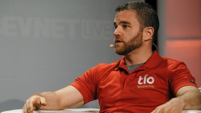A bearded man with a headset microphone sits and speaks, wearing a red polo shirt with the Tio Gazpacho logo. A BevNET Live backdrop is visible behind him.