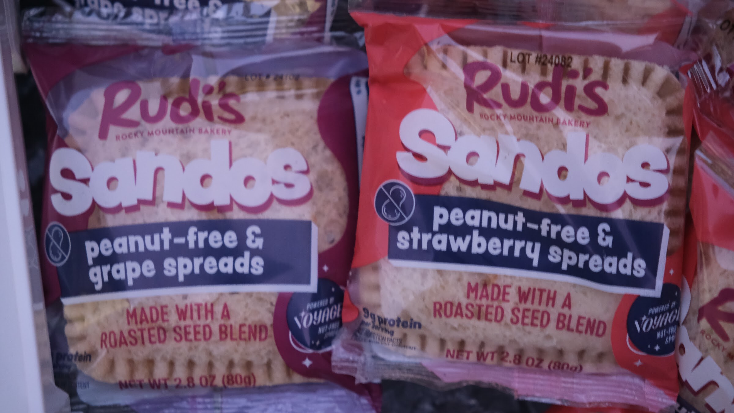 Two packages of Rudi's Sandos in grape and strawberry spreads, labeled peanut-free.