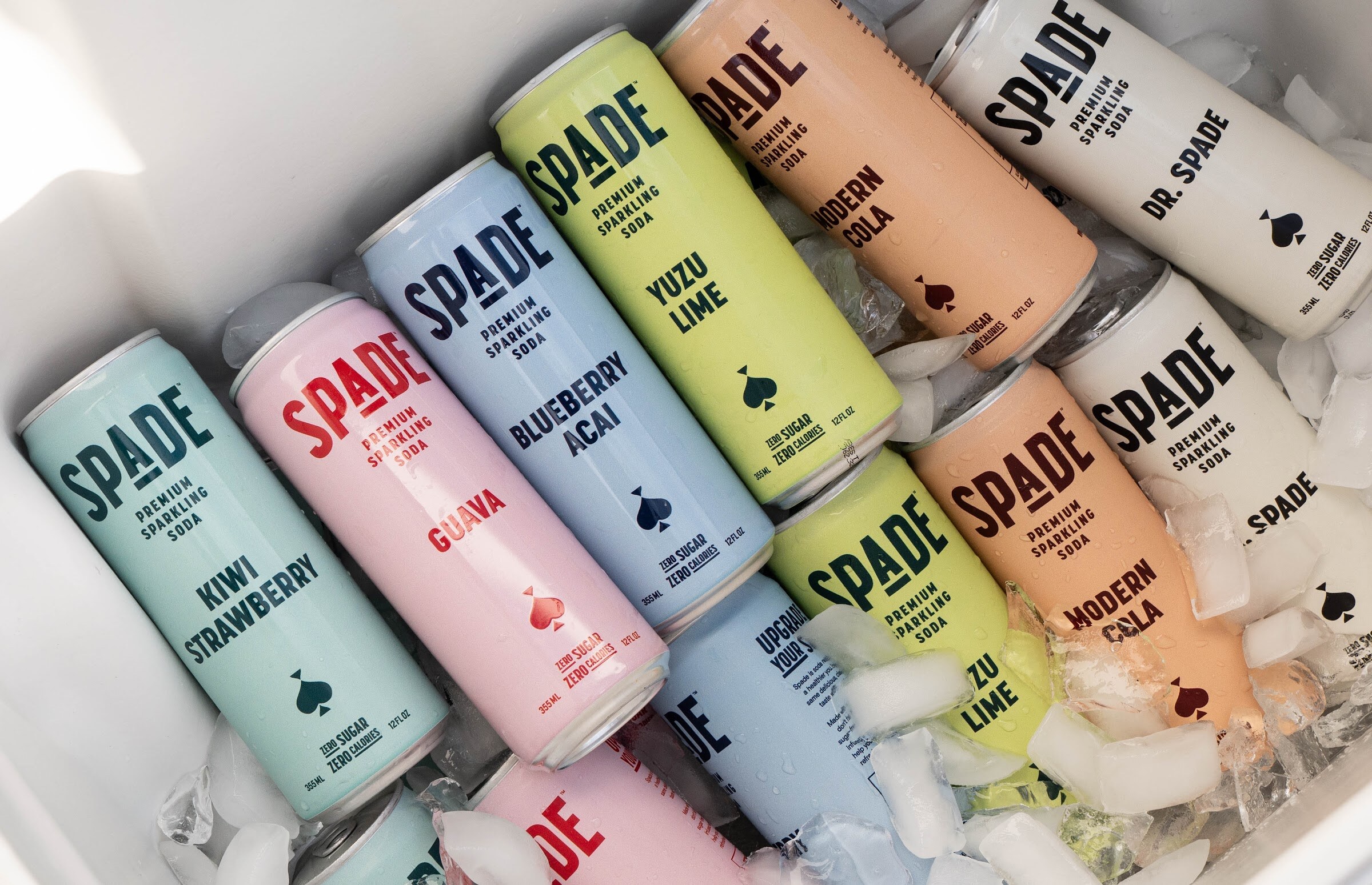 Overhead view of Spade soda cans in several flavors in a cooler of ice.
