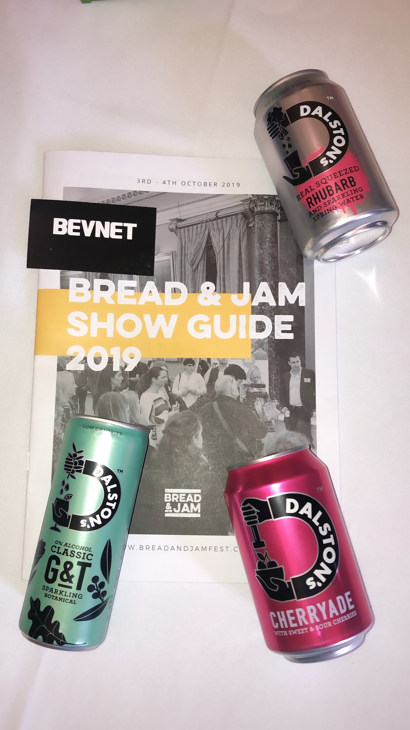 A printed Bread & Jam Show Guide 2019 with three Dalston's cans and a BevNET label on top of it.