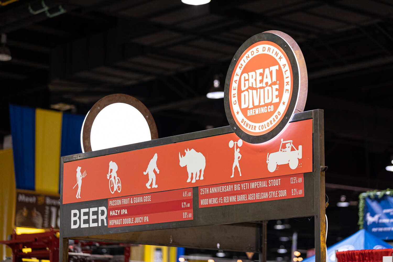 An orange Great Divide Brewing Co. sign with illustrated icons above a short beer list.