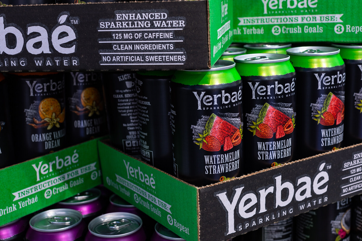 Green and black Yerbae cartons with Watermelon Strawberry and Orange Vanilla Dream cans in front.