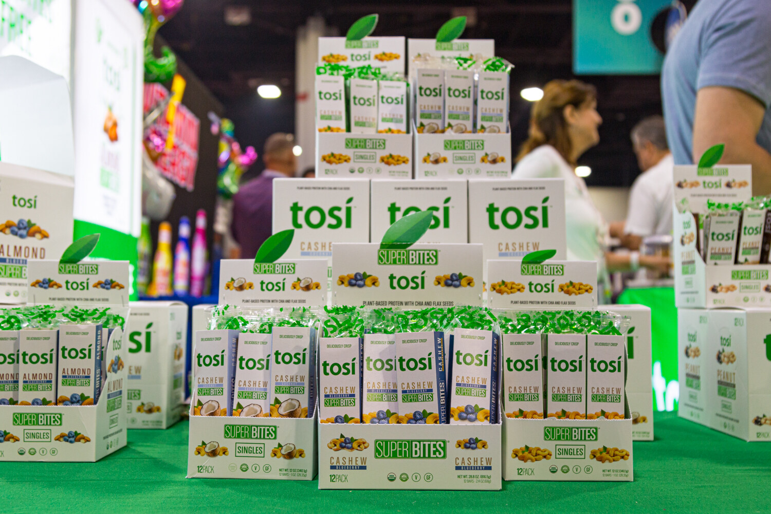 Pyramids of Tosi boxes on green turf with visitors walking behind.