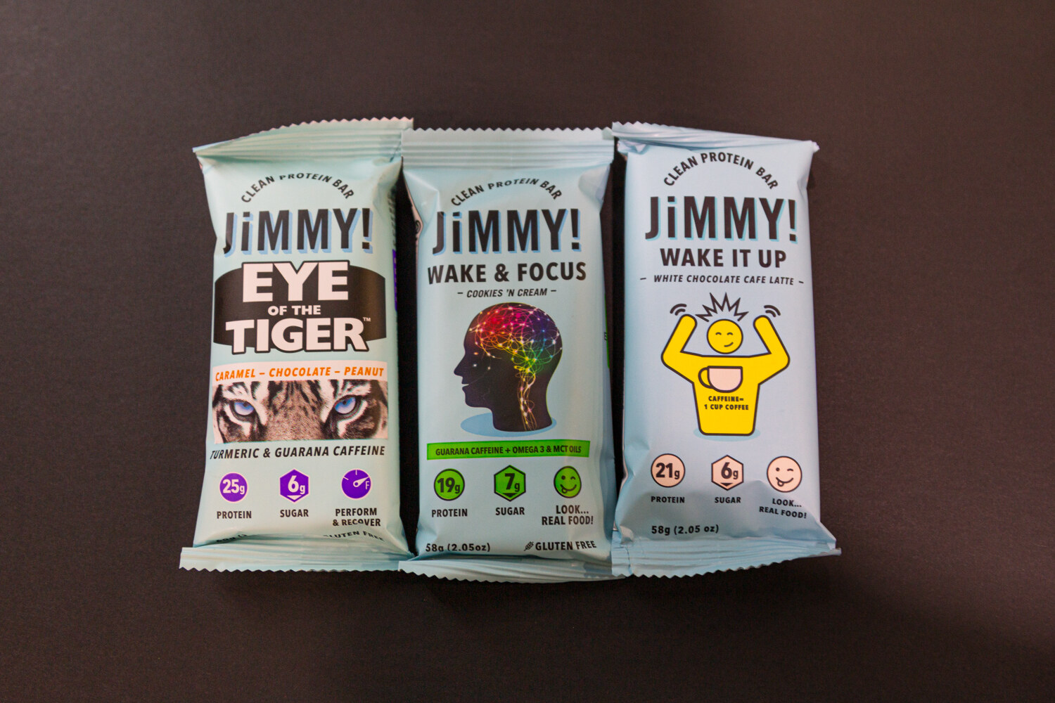 Three JiMMY! bars labeled Eye of the Tiger, Wake and Focus and Wake It Up on a dark brown background.