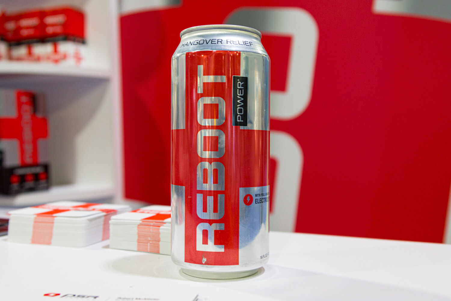 A red REBOOT can on a white counter with REBOOT cards beside it.