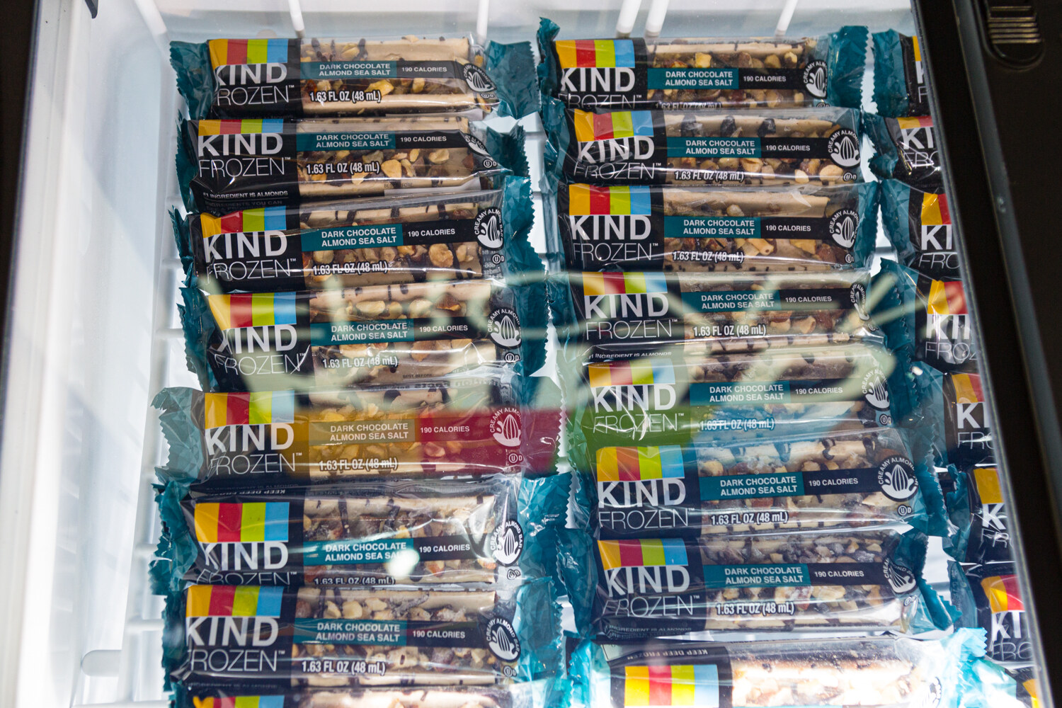 Rows of KIND Frozen almond bars in a case.