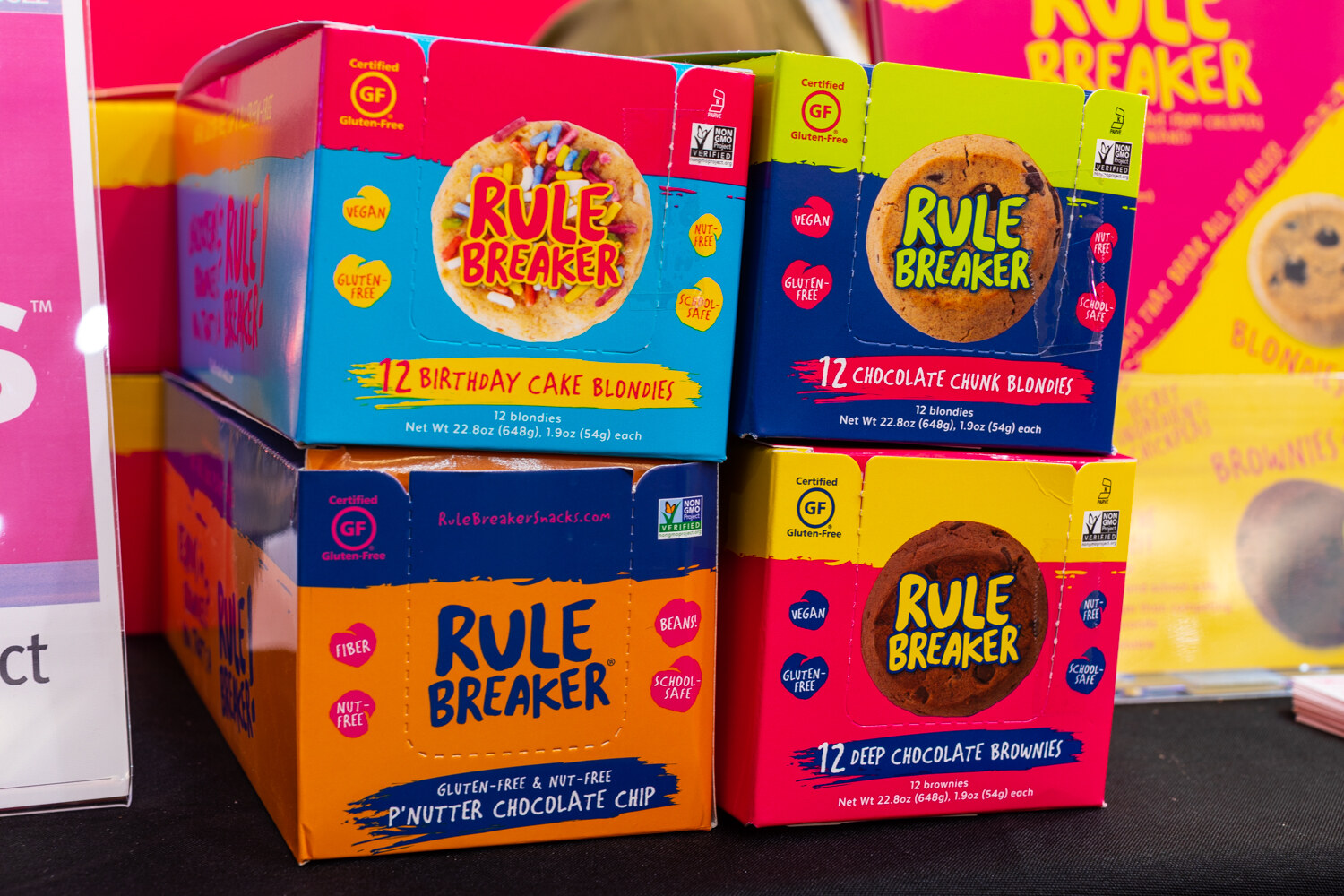 Four colorful Rule Breaker boxes stacked two high on a black table.