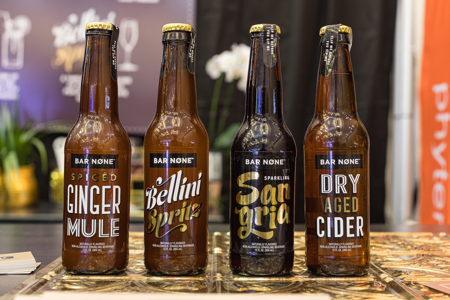 Four dark glass bottles labeled Bar None on a gold-colored tray.