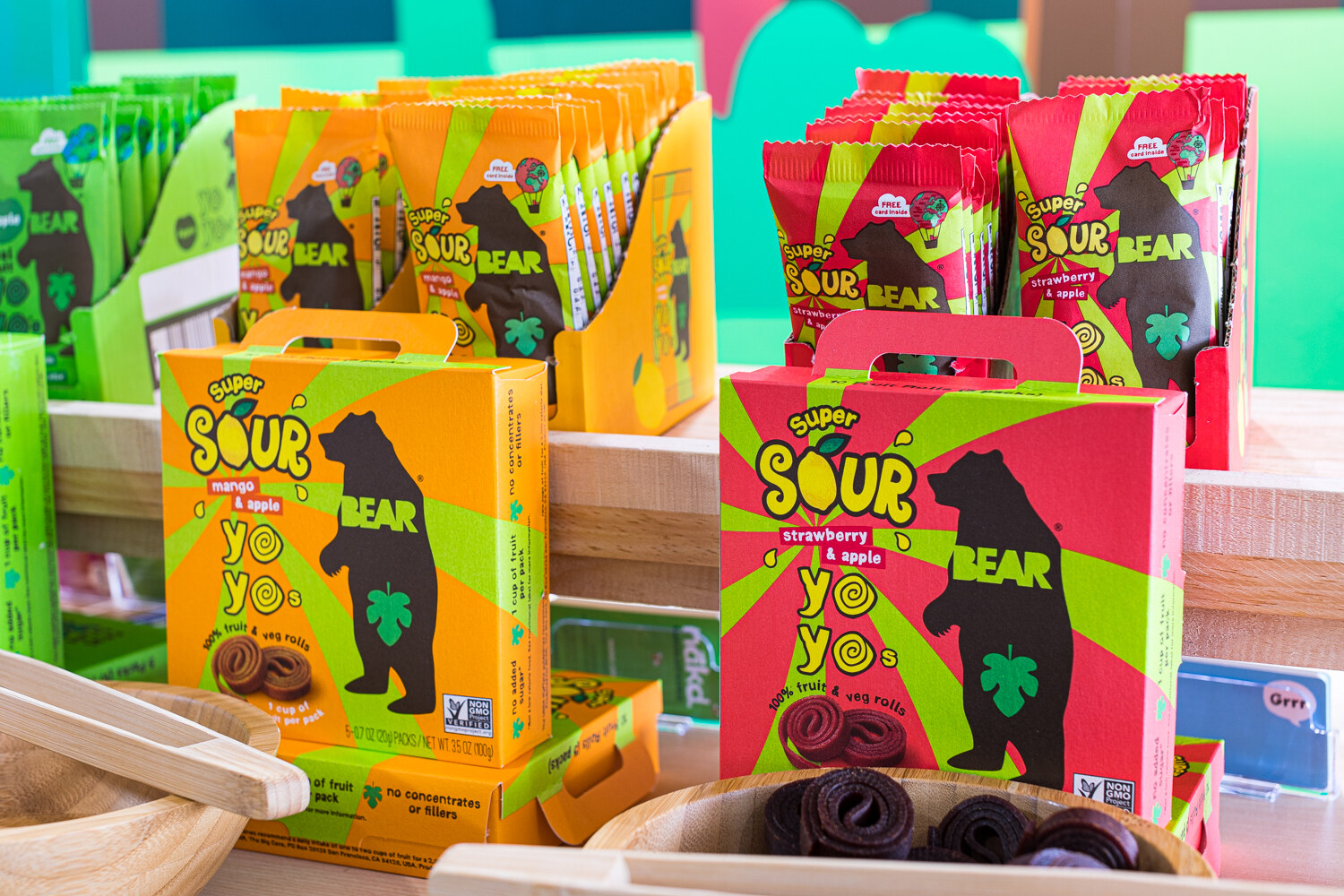 Colorful boxes labeled Super Sour Bear Yo Yos with a bowl of fruit rolls.