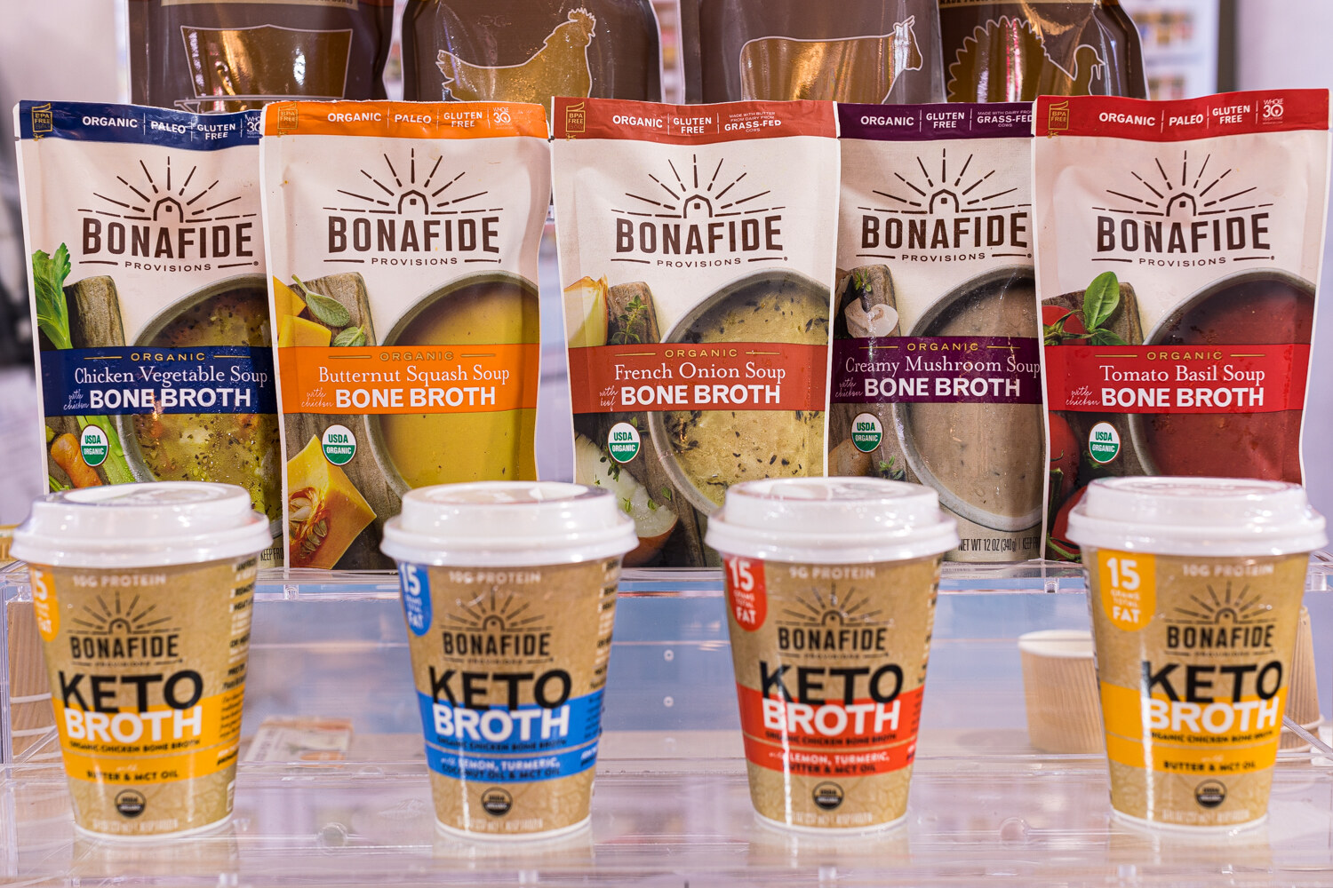 Bags of Bonafide Provisions bone broth soup above takeaway cups labeled Keto Broth.