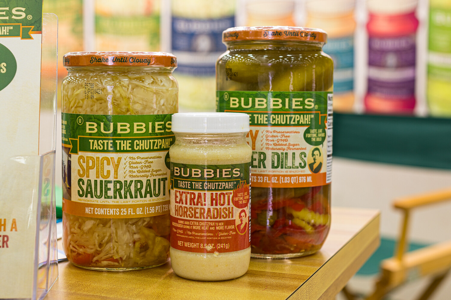 Three jars of Bubbies products beside a director's chair arm.