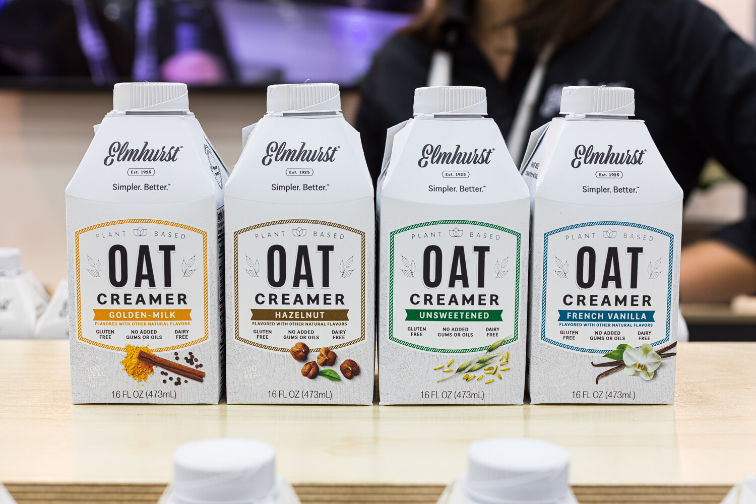 Four Elmhurst Oat Creamer cartons, including Golden Milk, Hazelnut, Unsweetened and French Vanilla.