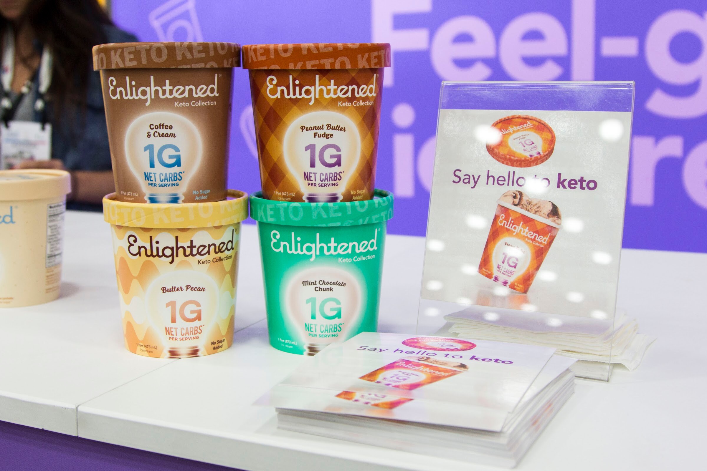 Pints of Enlightened Keto Collection ice cream in several flavors next to a sign with the word keto.