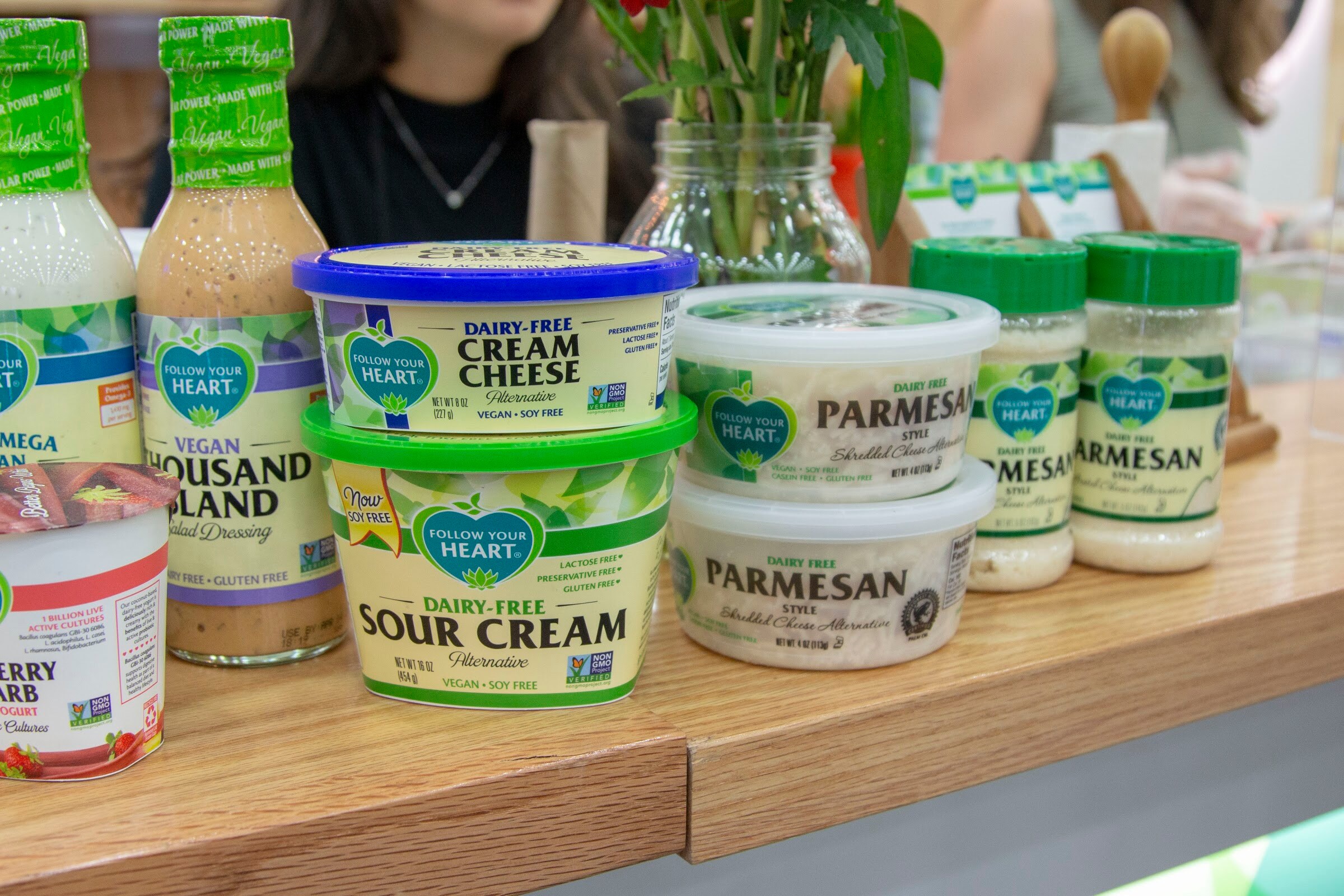 Tubs of Follow Your Heart cream cheese and sour cream with parmesan shakers and dressing bottles.
