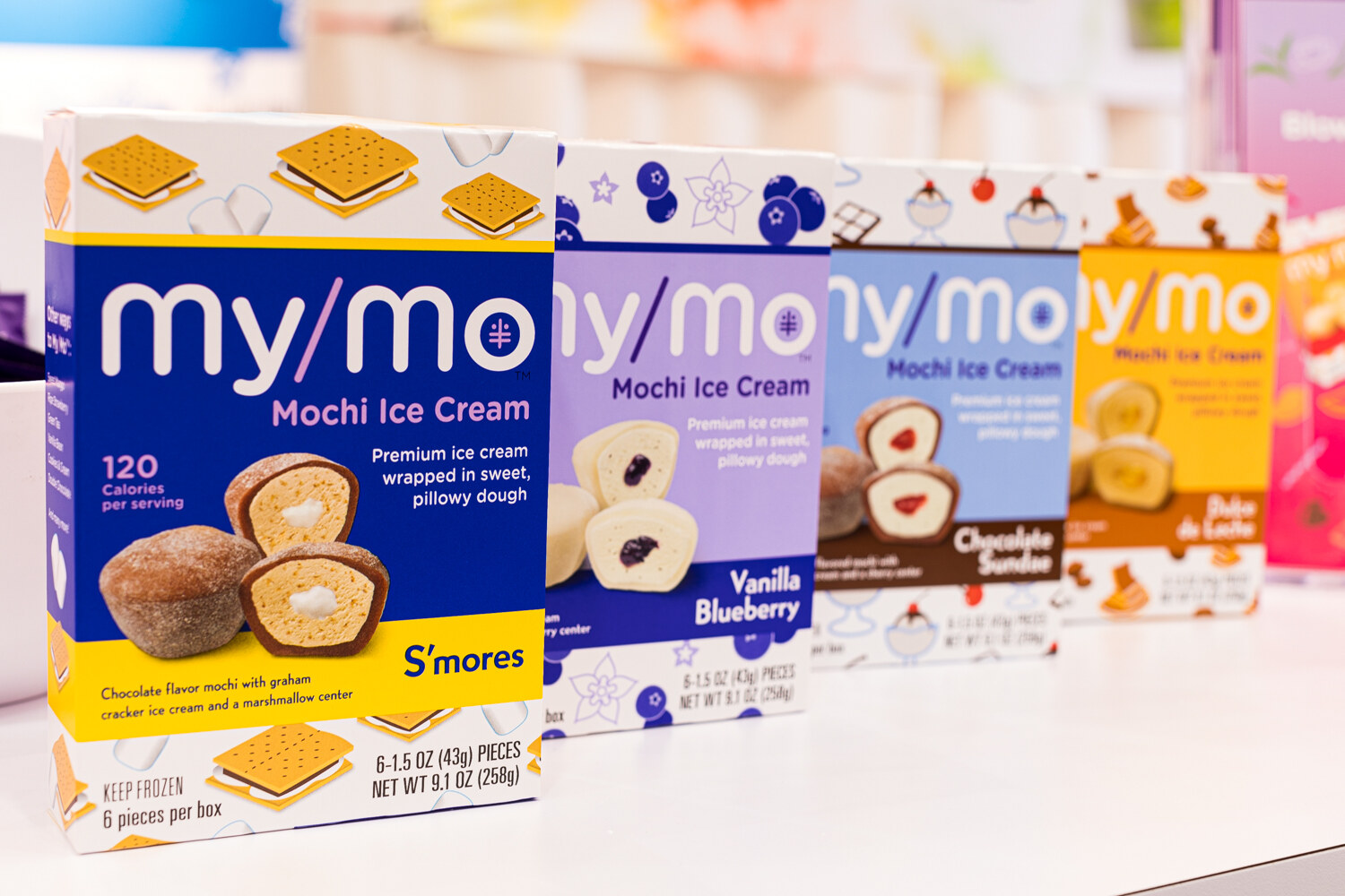 A row of my/mo Mochi Ice Cream boxes with illustrated packaging.