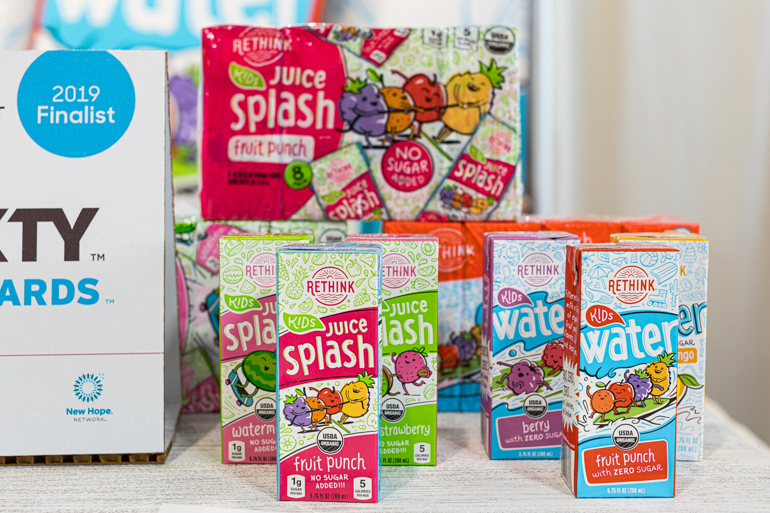 Colorful Rethink Juice Splash and Water cartons next to a sign reading 2019 Finalist.