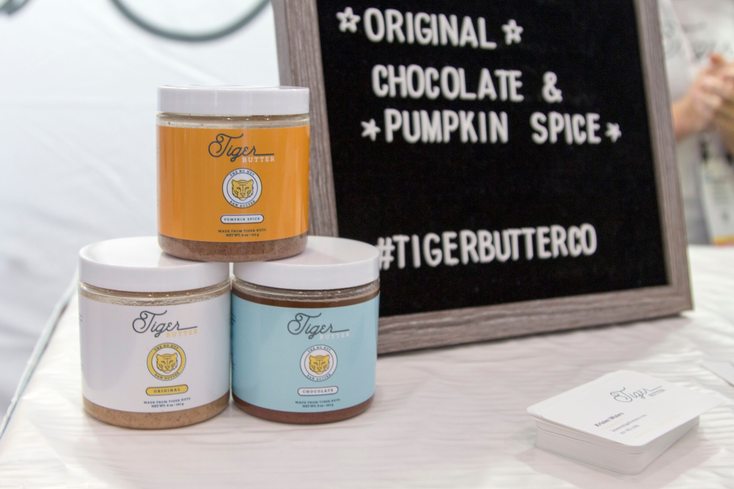 Three stacked jars labeled Tiger beside a felt letter board reading Original, Chocolate and Pumpkin Spice.