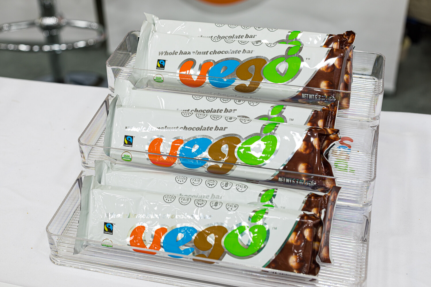 Rows of Vego chocolate bars in white wrappers with colorful lettering in a clear display tray.