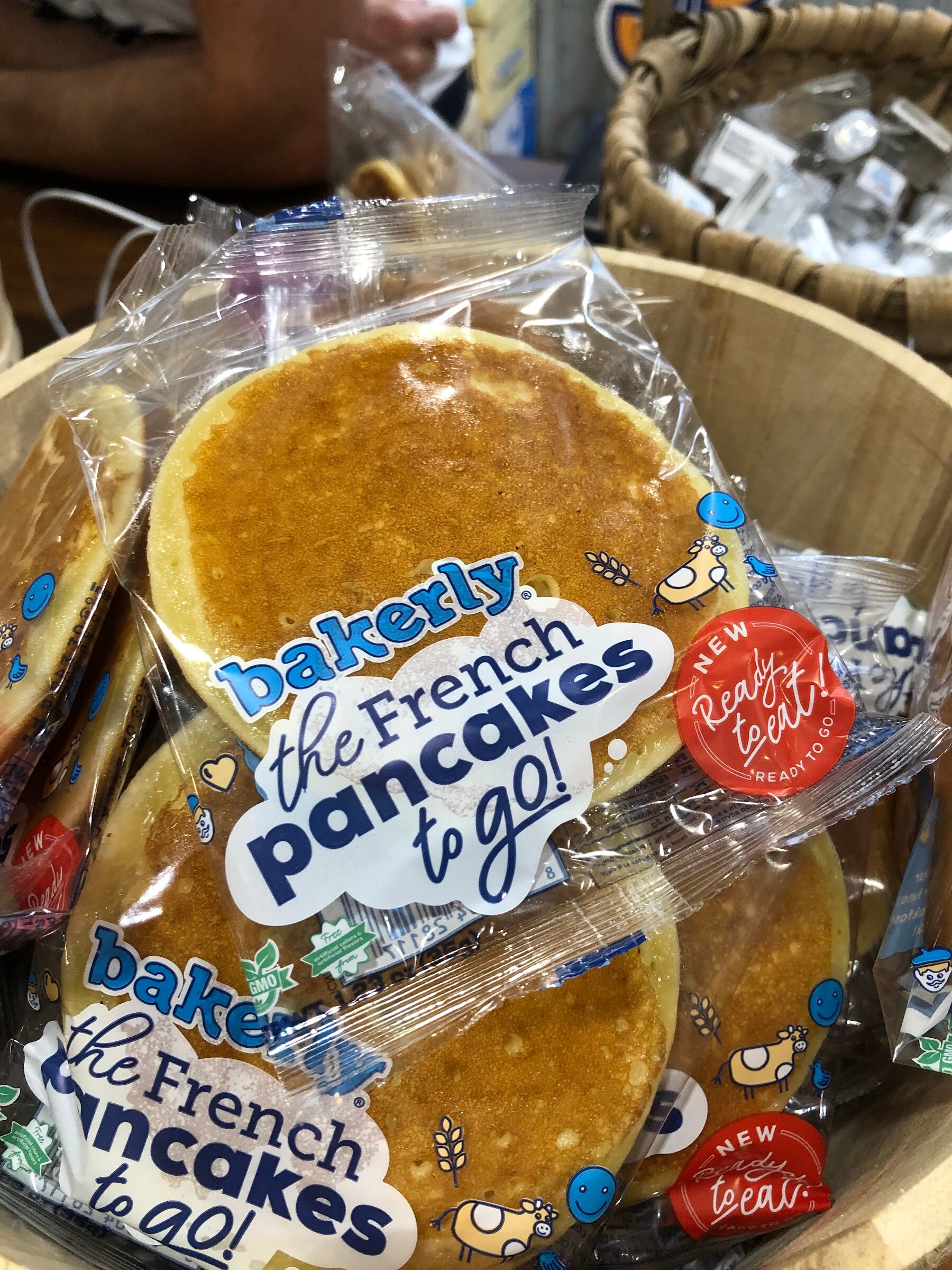 Packages of bakerly the French pancakes to go piled in a wooden basket