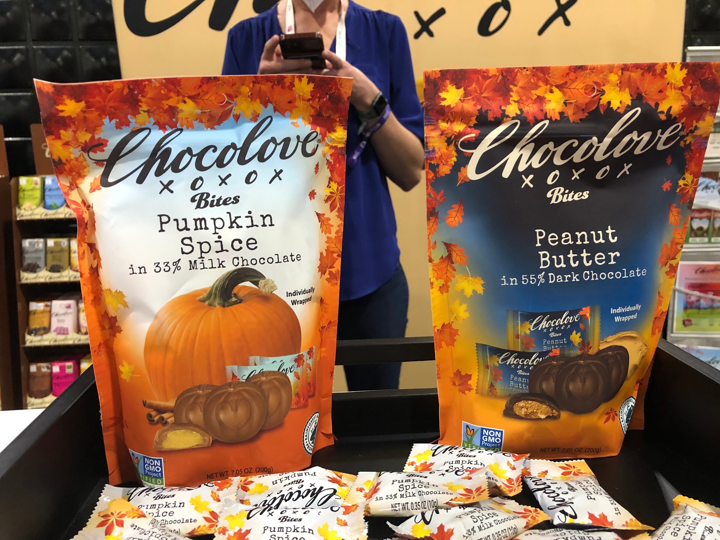 Chocolove Bites pouches in pumpkin spice and peanut butter flavors with fall leaf designs on a display