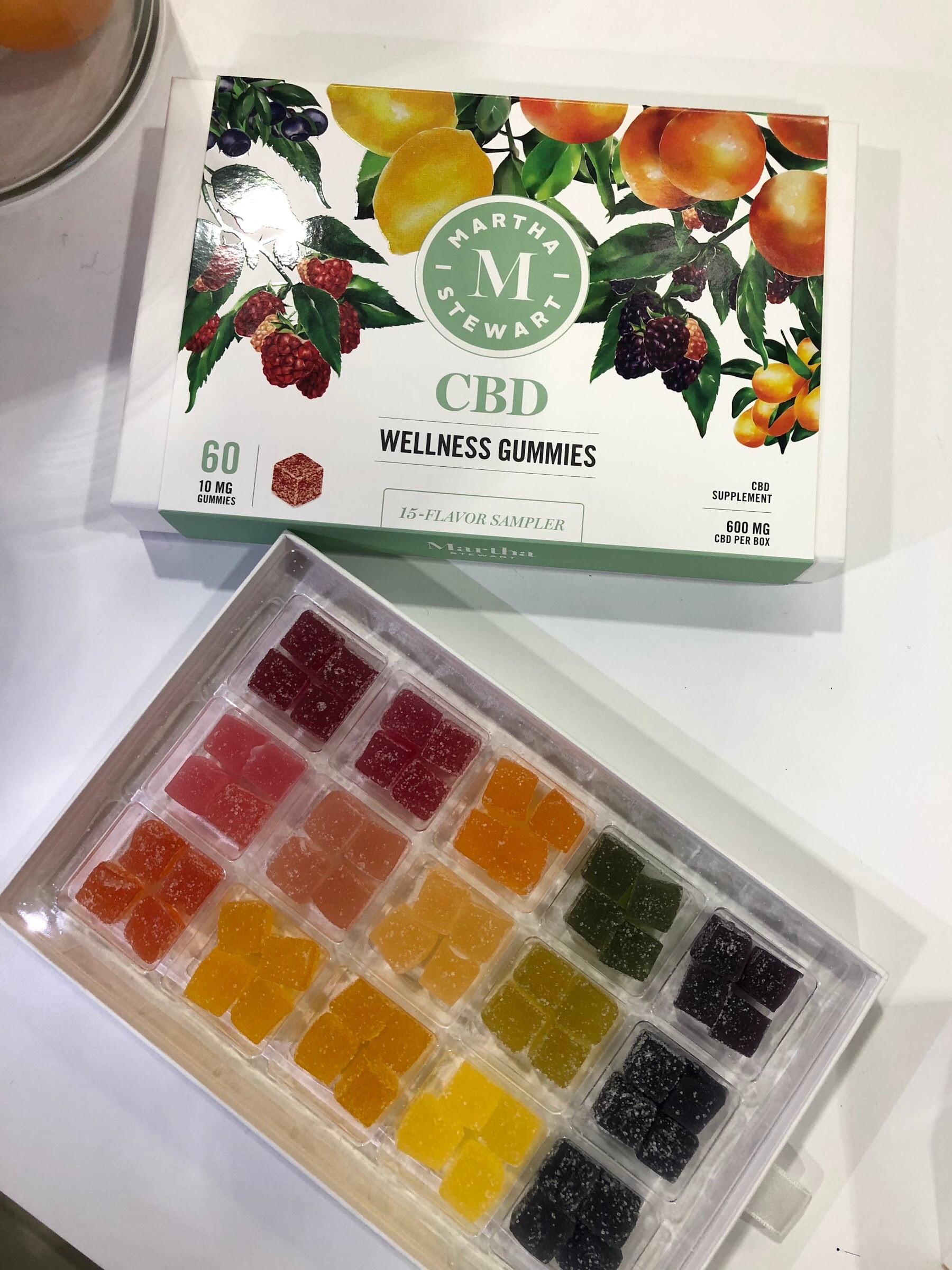 An open Martha Stewart CBD wellness gummies box showing rows of colorful gummies beside the box lid