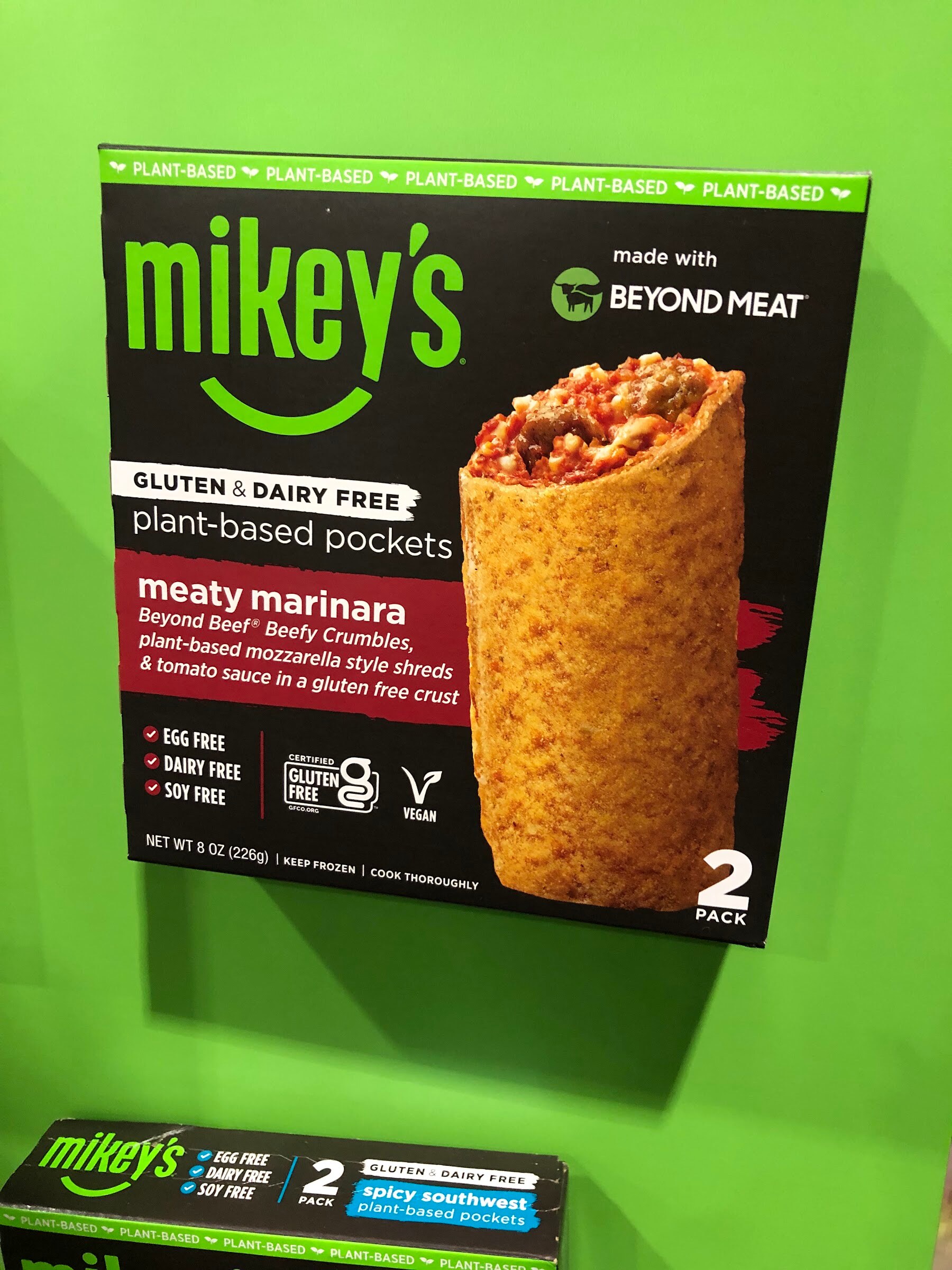 A mikey's meaty marinara plant-based pockets box, made with Beyond Meat, mounted on a green wall