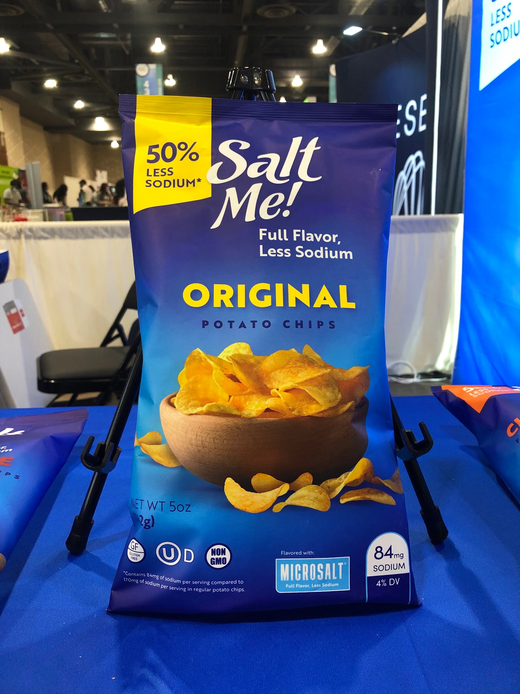 A Salt Me! original potato chips bag with 50 percent less sodium on a blue display