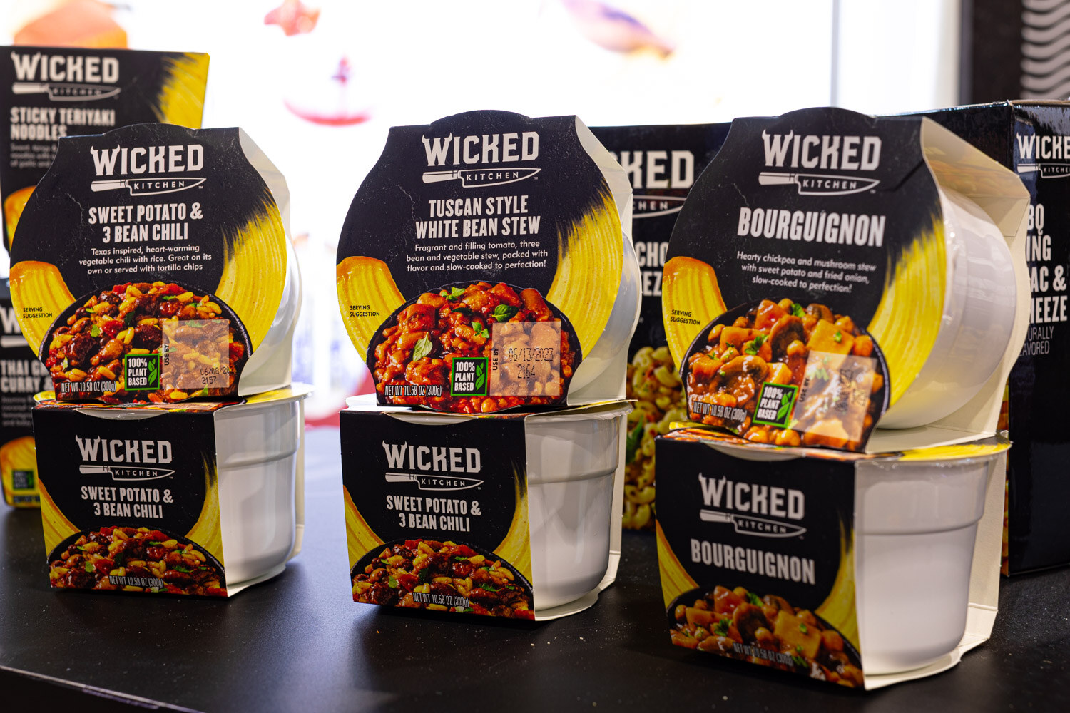 Wicked Kitchen ready meal bowls including Sticky Teriyaki Noodles, Tuscan Style White Bean Stew and Bourguignon stand on a shelf