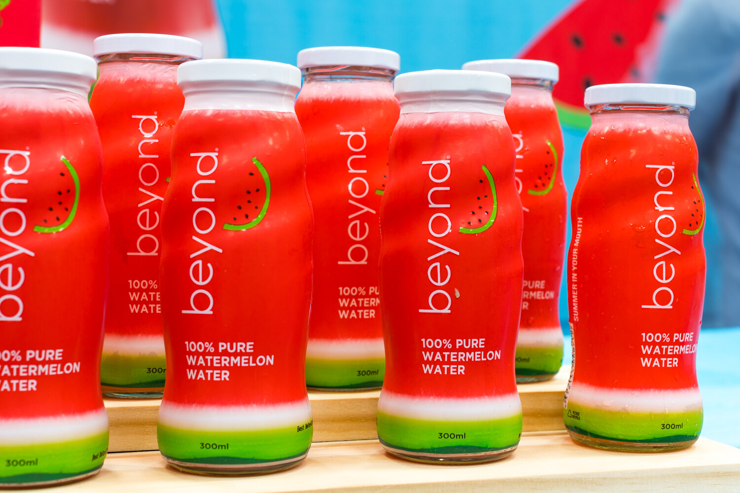 Several red bottles with watermelon-green bases labelled beyond 100% pure watermelon water.