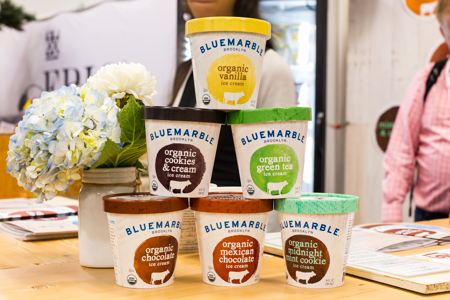 Stacked pints of Bluemarble organic ice cream in vanilla, cookies and cream, green tea, chocolate, Mexican chocolate and midnight mint cookie.
