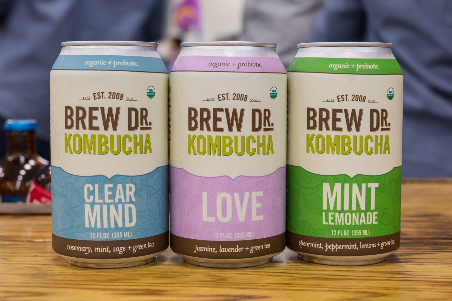 Three cans of Brew Dr. Kombucha labelled Clear Mind, Love and Mint Lemonade.