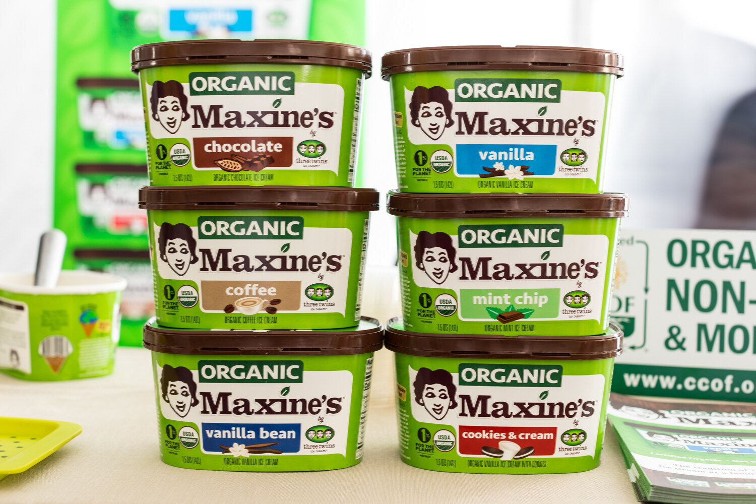 Six stacked tubs of Maxine's organic ice cream in chocolate, vanilla, coffee, mint chip, vanilla bean and cookies and cream.