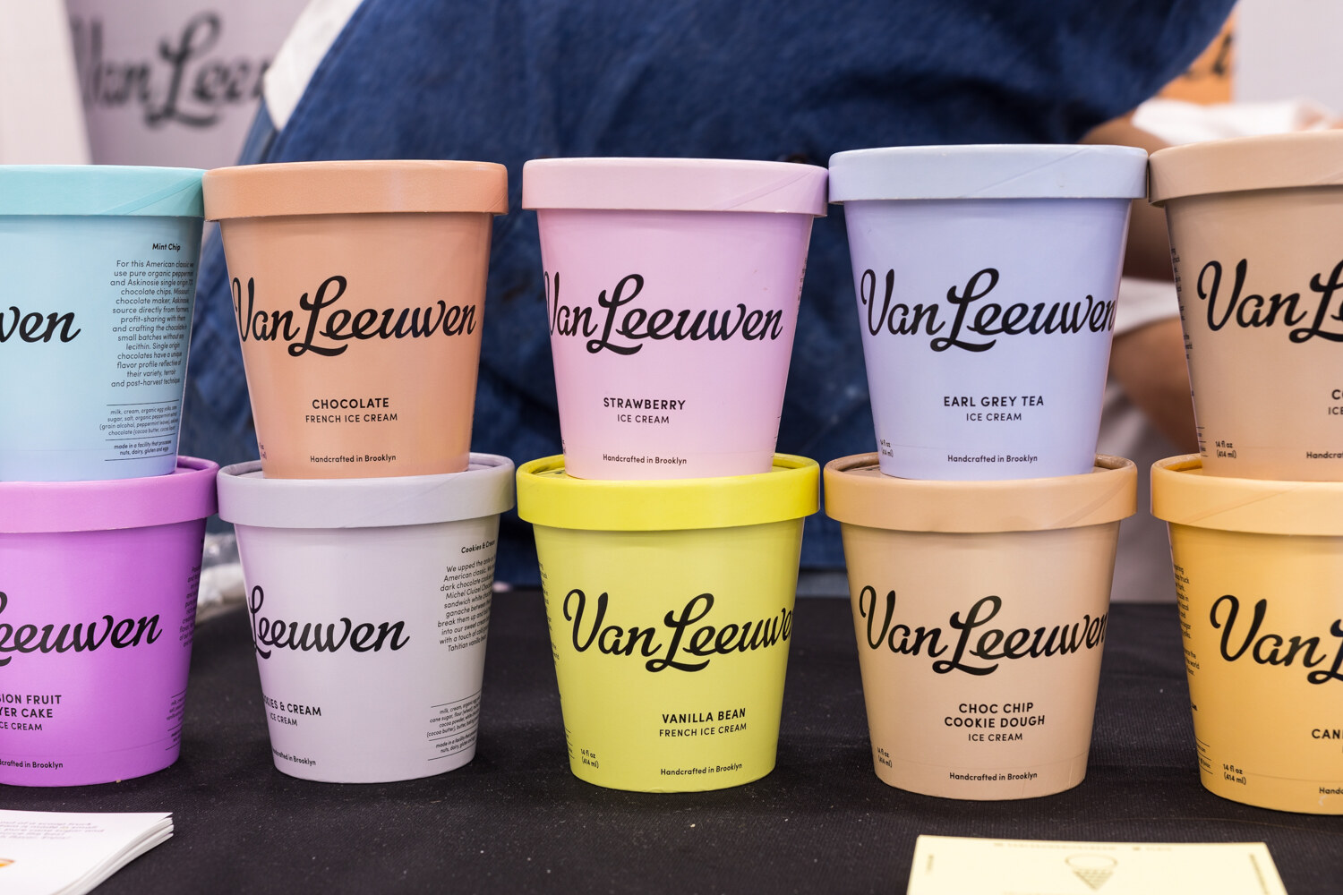 Two rows of pastel Van Leeuwen ice cream pints in chocolate, strawberry, Earl Grey tea, vanilla bean and chocolate chip cookie dough.