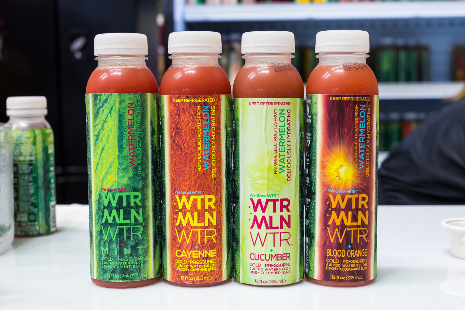 Four bottles of WTRMLN WTR in mint, cayenne, cucumber and blood orange flavors.