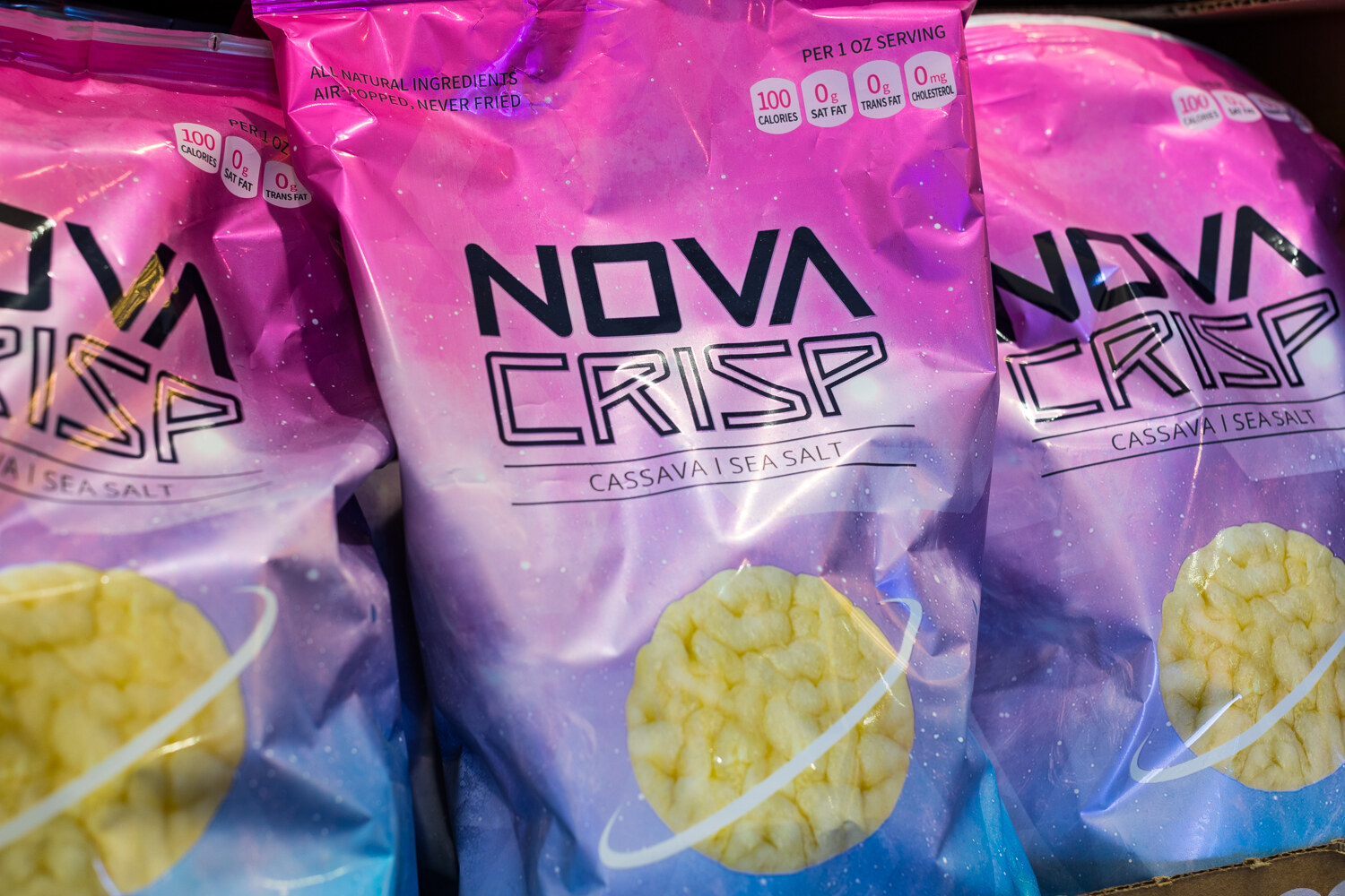 Large pink and purple Nova Crisp bags with a yellow chip visible through the window.