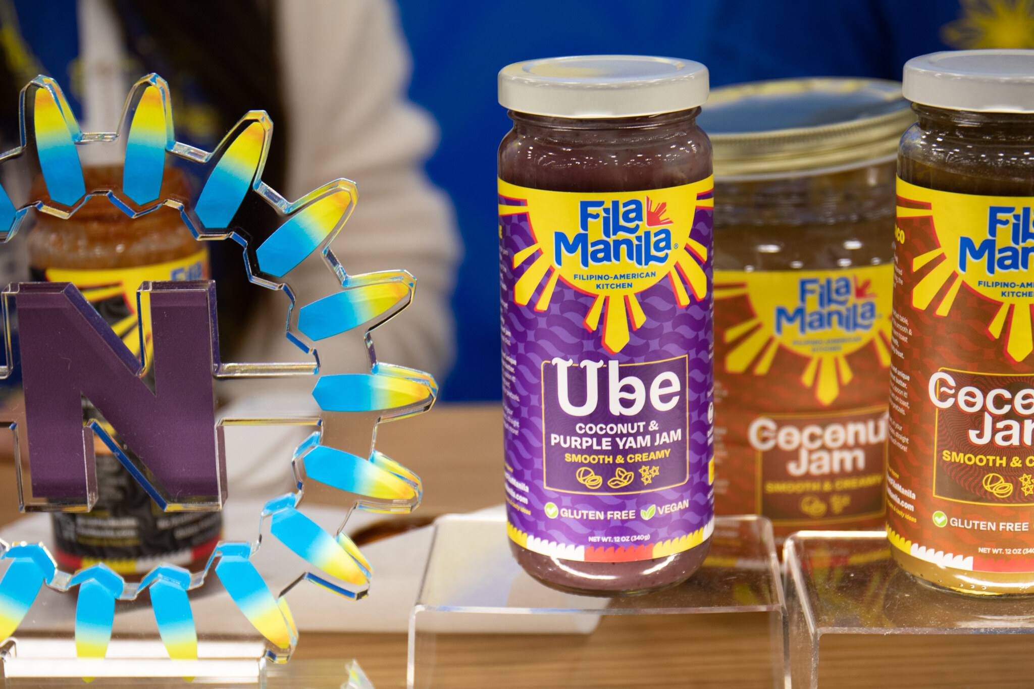 Jars of Fila Manila Ube and Coconut jam sit beside a purple Nexty Awards trophy on a clear stand