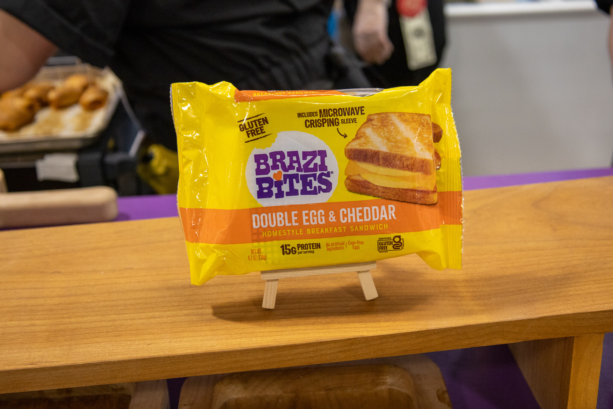 A package of Brazi Bites double egg and cheddar breakfast bites on a wooden stand