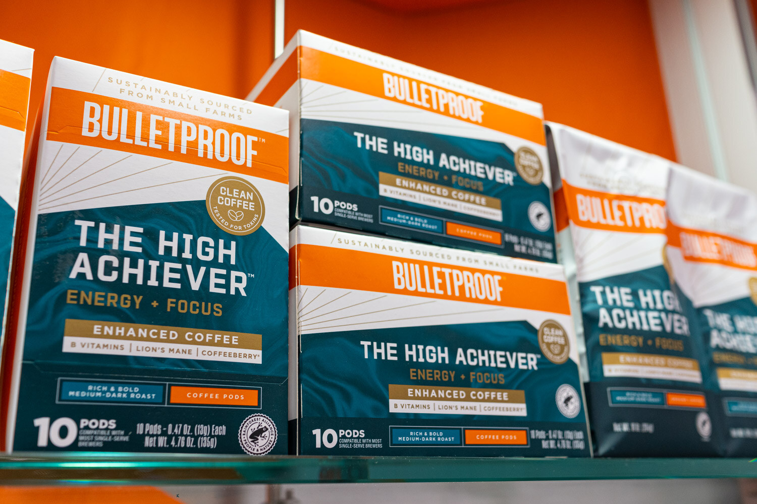 Stacks of Bulletproof The High Achiever coffee pod boxes on a shelf