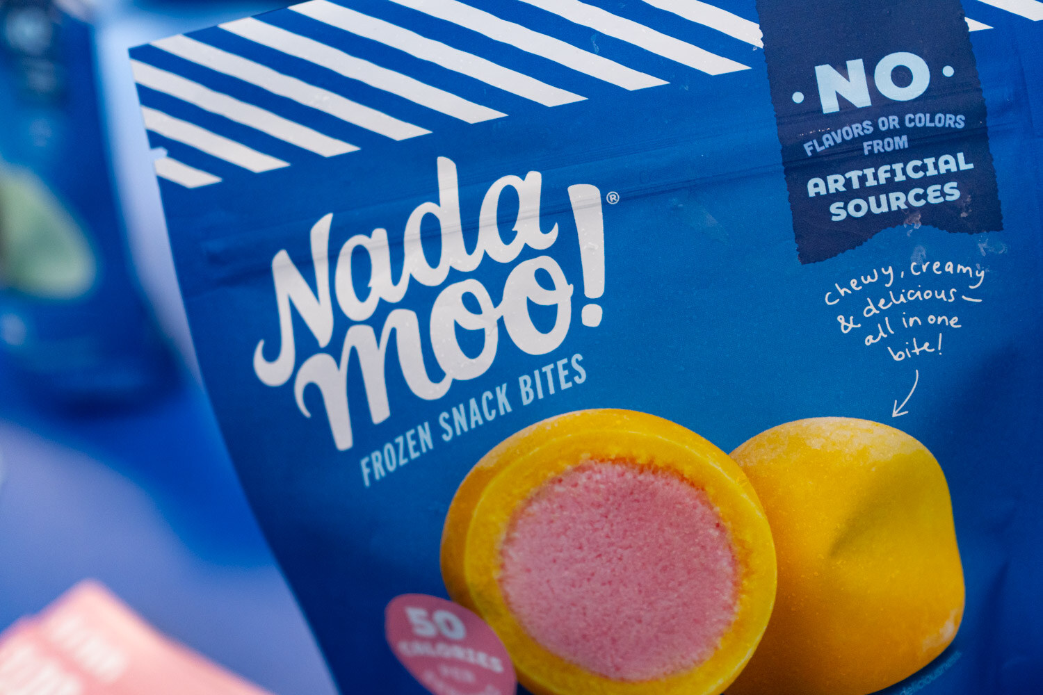 A close view of a Nadamoo frozen snack bites bag showing a mango bite with a pink center